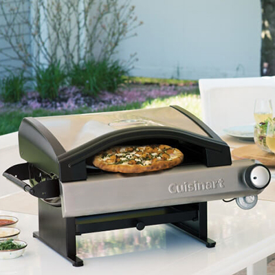 CUISINART<sup>&reg;</sup> Outdoor Pizza Oven - This oven cooks wood fired style pizza in 5 to 7 minutes and has a built-in smoker box providing real wood fired taste.  15,000 BTU’s with up to 700F air temperature utilizes a 13" Diameter Baking stone to evenly distribute heat. Also, features a push and twist ignition that lights the oven and stainless steel lid/ accents. The lid system hinges like a grill for easy cleaning and it’s portable/ compact to take anywhere. Uses 1lb propane tank which converts to 20lb with hose. 
